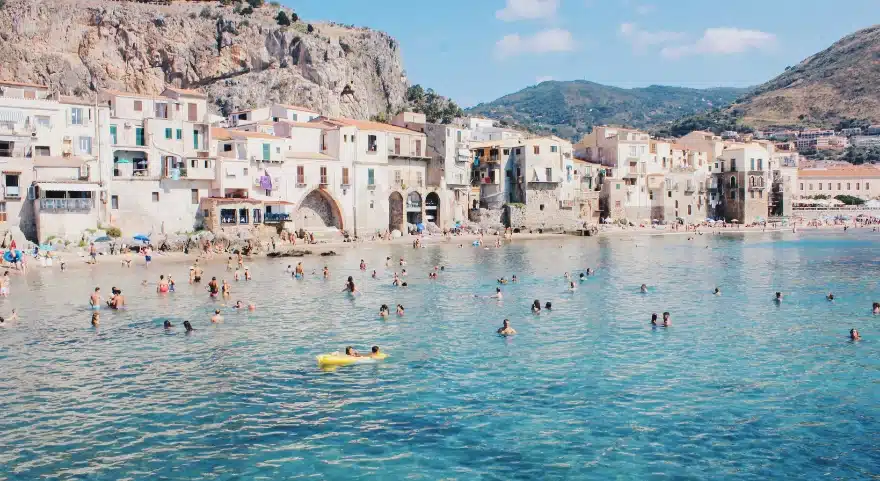 bunch of people swimming beach in Taormina