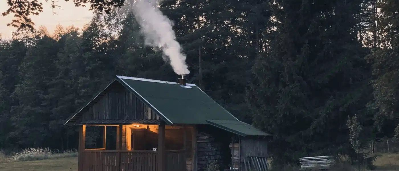 Birch logs burning in the stone stove of a traditional smoke sauna