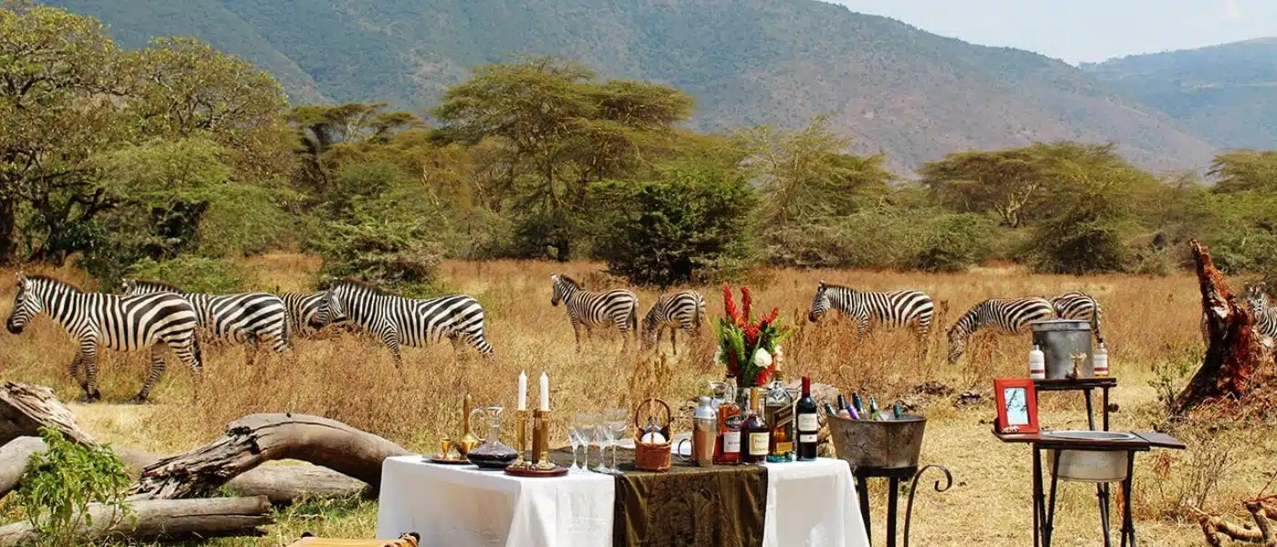 Maasai dancers performing beside a private dinner table at dusk