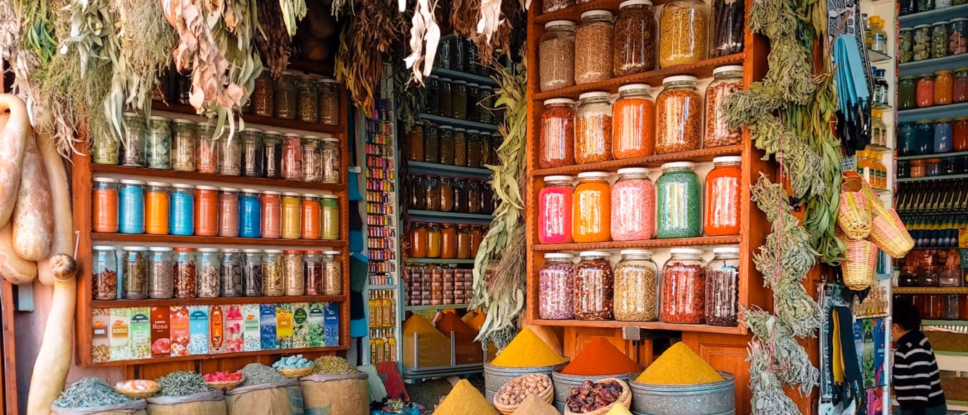 Chef choosing tomatoes and spices at a Marrakech market stall