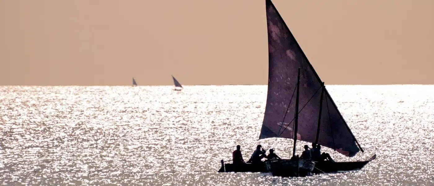 Dhow sail billowing against a clear Zanzibar sky