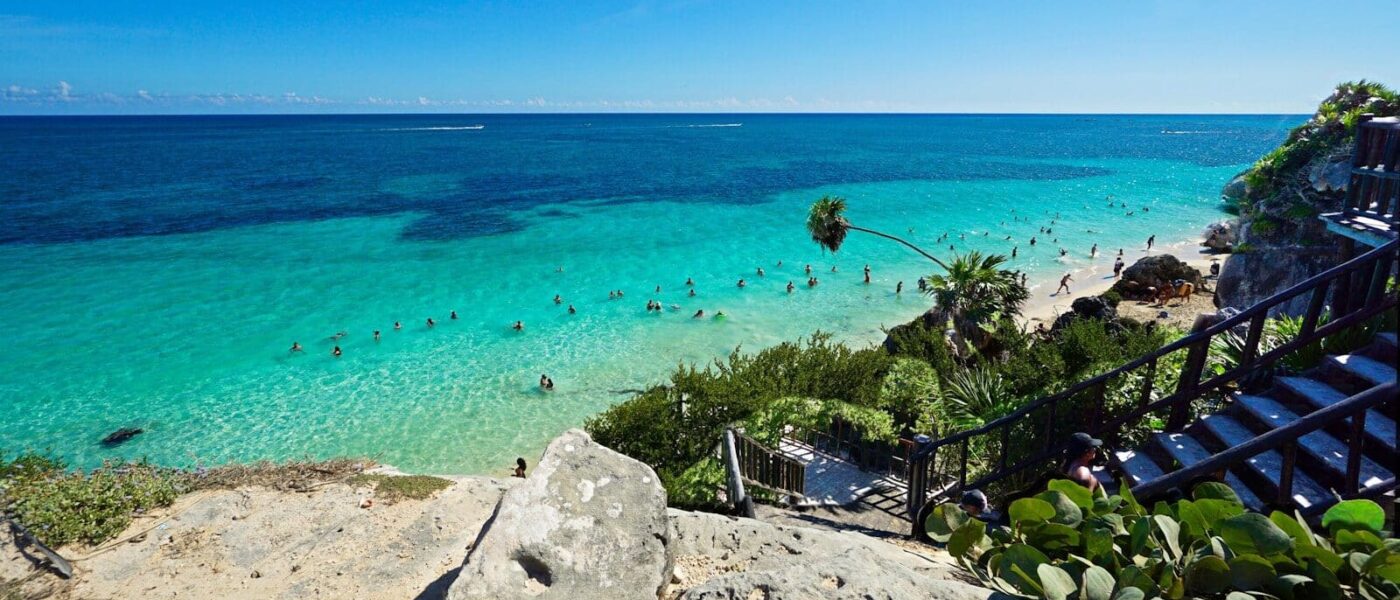 Swimmers in calm water beside a private yacht off the Riviera Maya