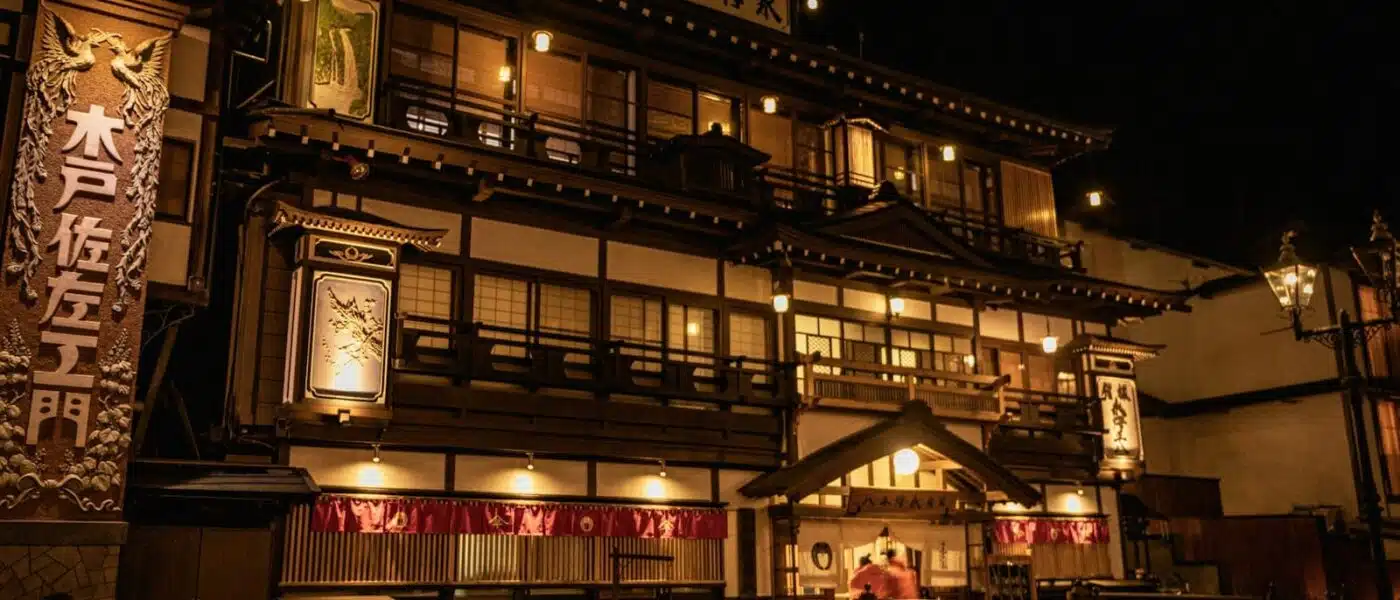 Wooden bathhouse beside the canal in Kinosaki at dusk