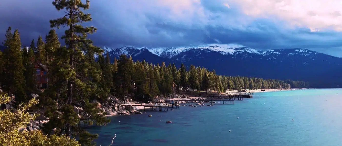 Paddleboarder gliding over glassy water at dawn on Lake Tahoe