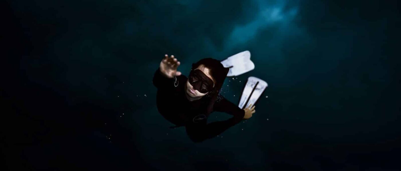 Guide with main and backup torches checking on snorkelers