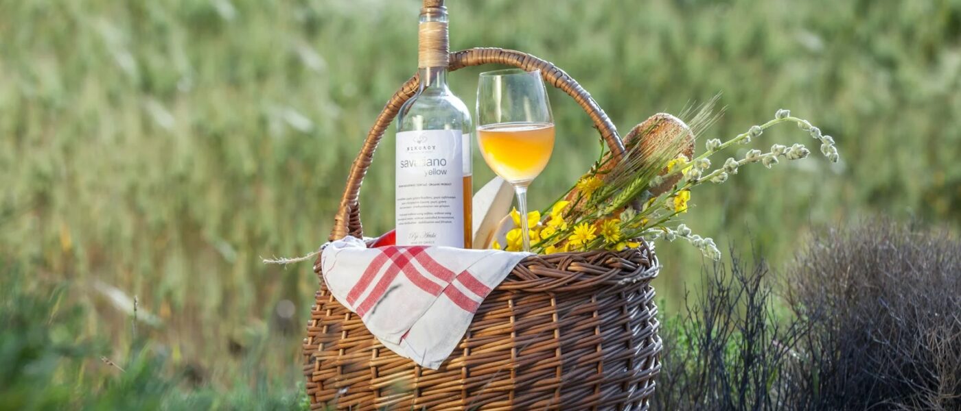 a bottle of wine sitting in a basket next to a bottle of wine