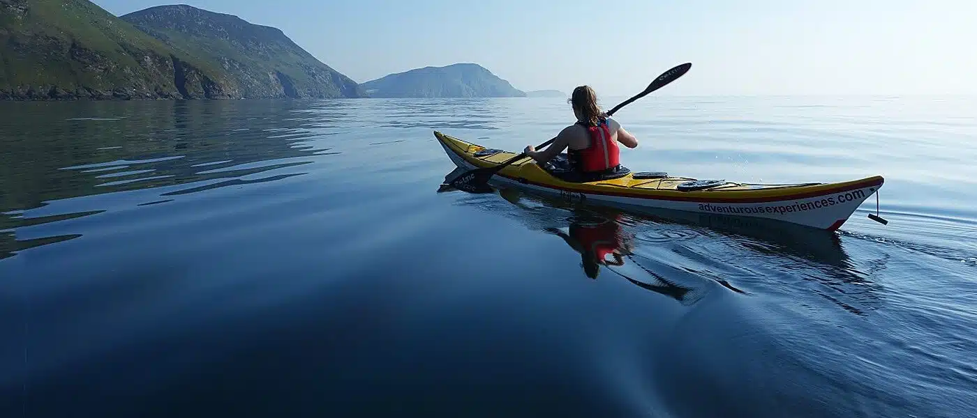 Guide assessing the swell before leading a kayak into a cave