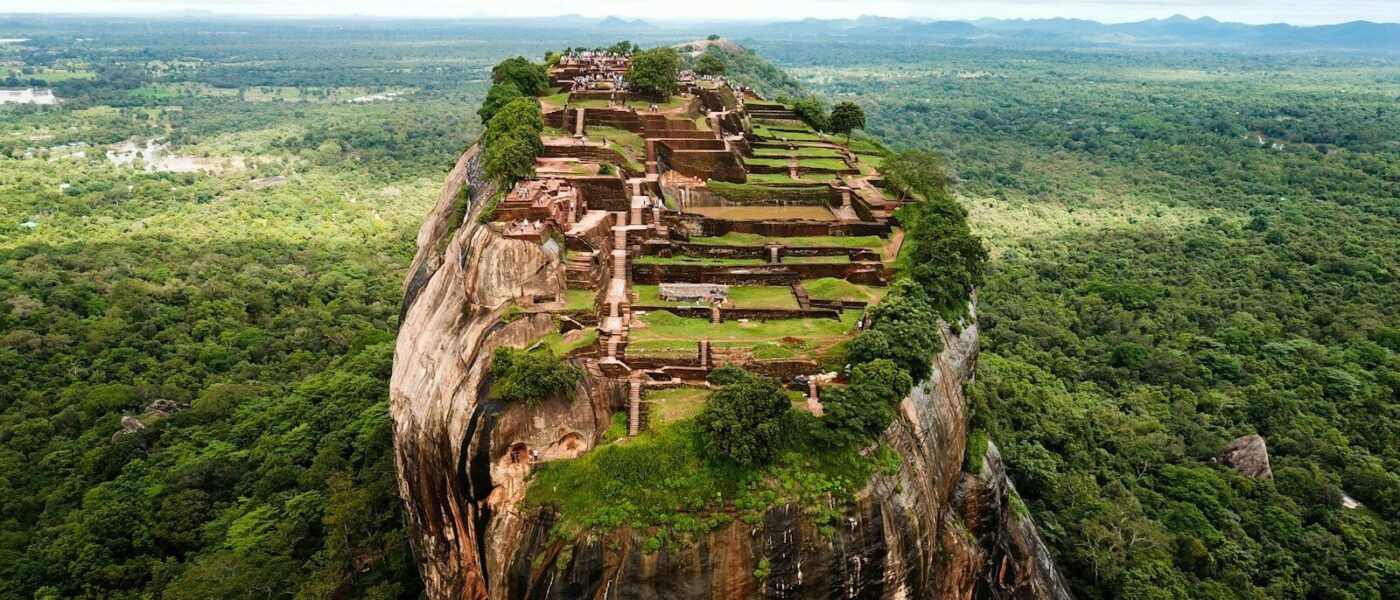 Aerial view of the Sigiriya rock fortress rising above a dense green forest