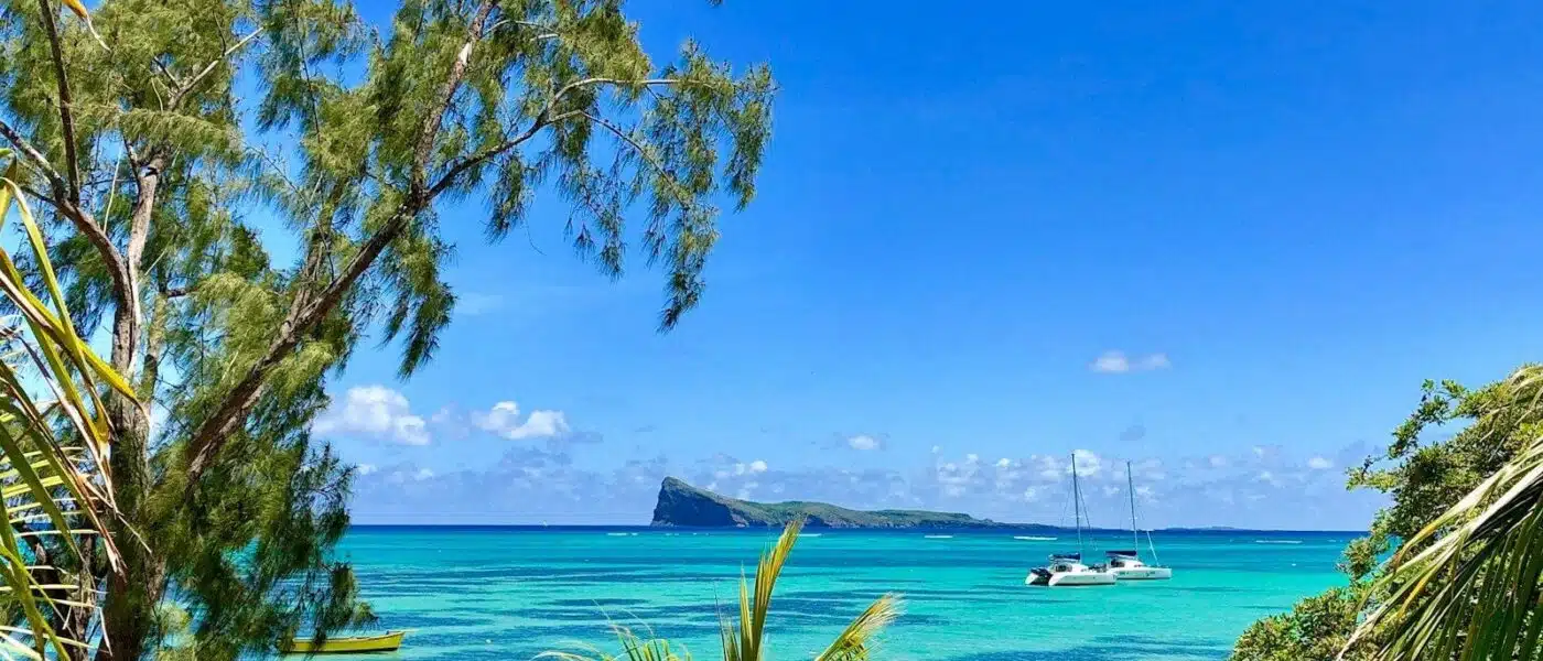 Dawn side-light on volcanic rock and turquoise water at Le Morne