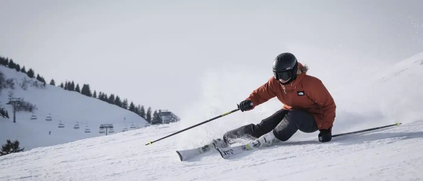 Skier carving first tracks down the wide upper glacier