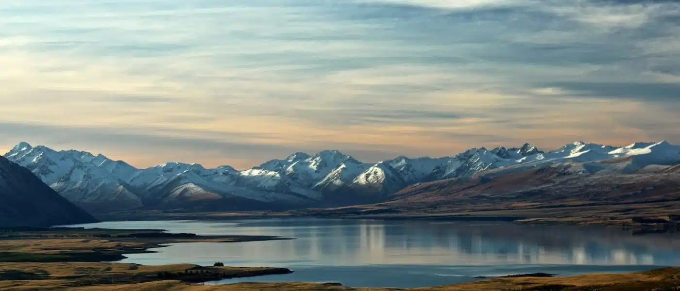 Glacial blue Lake Tekapo framed by tawny grassland and mountains