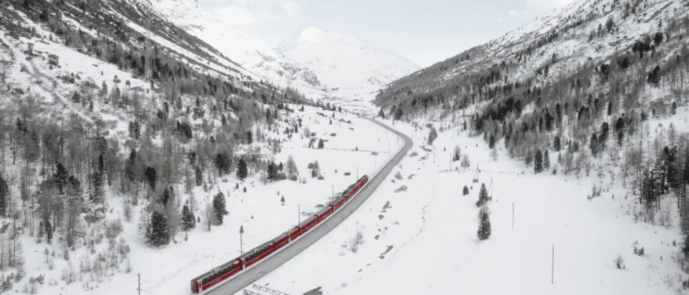 Panoramic windows framing snowy peaks from inside a carriage