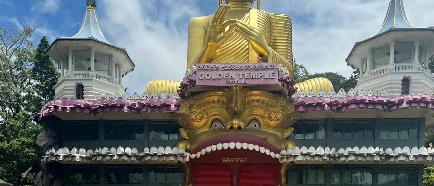 Row of seated and reclining Buddha statues inside a cave shrine