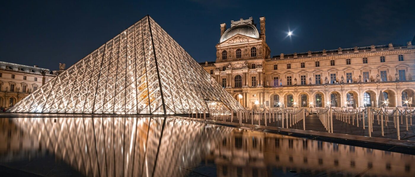 Louvre courtyard and Paris rooftops at dusk