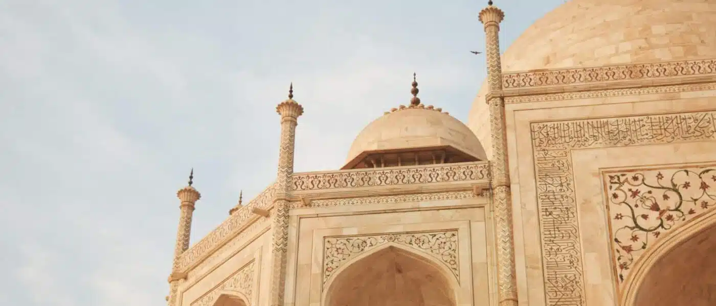Red sandstone gateway framing the first view of the Taj Mahal