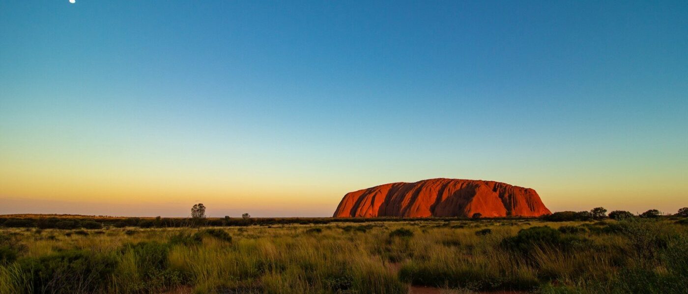 Uluru glowing red in the Australian desert