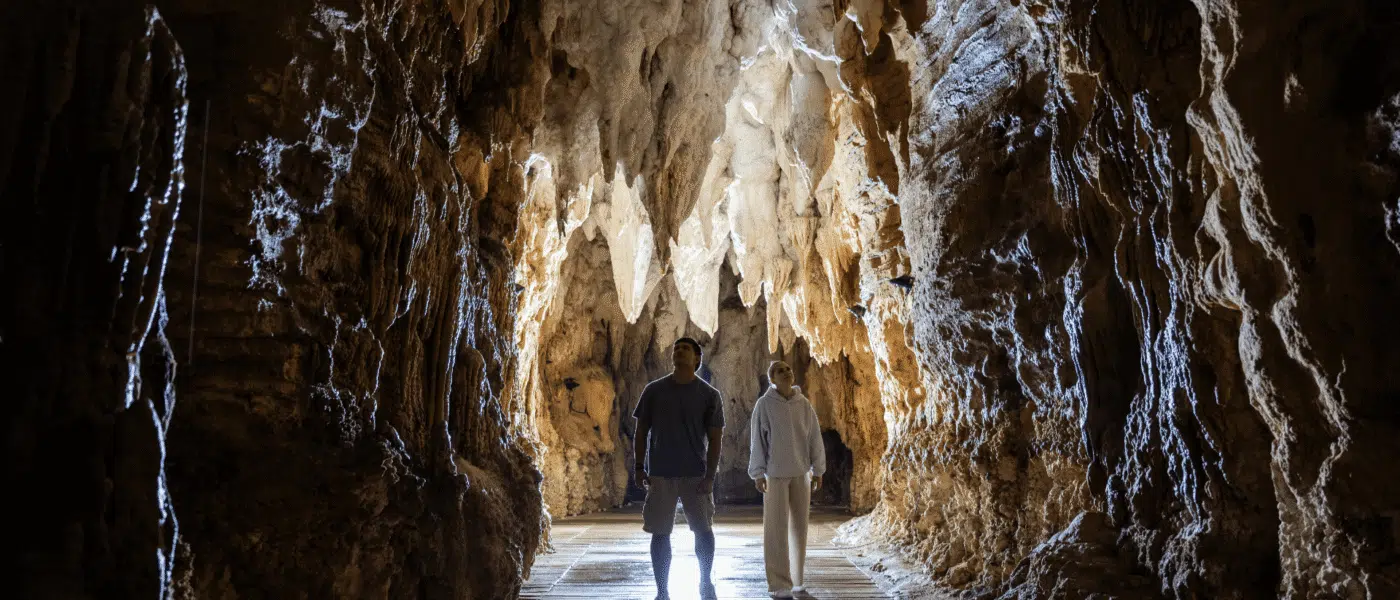 Guide pointing out a formation to a small group in a cave