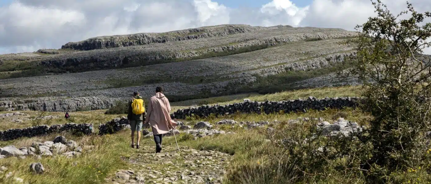 Walkers crossing limestone pavement in the Burren