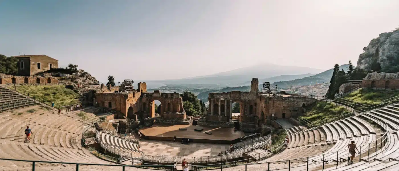 brown concrete building near green trees during daytime - taormina